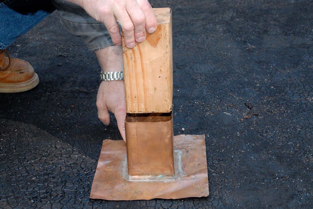 Copper flashing fits around post