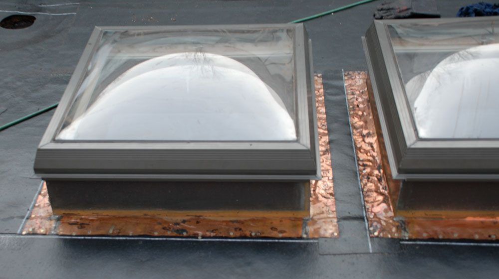 Skylight flashing on top of base roof layer Skylight flashing on top of base roof layer