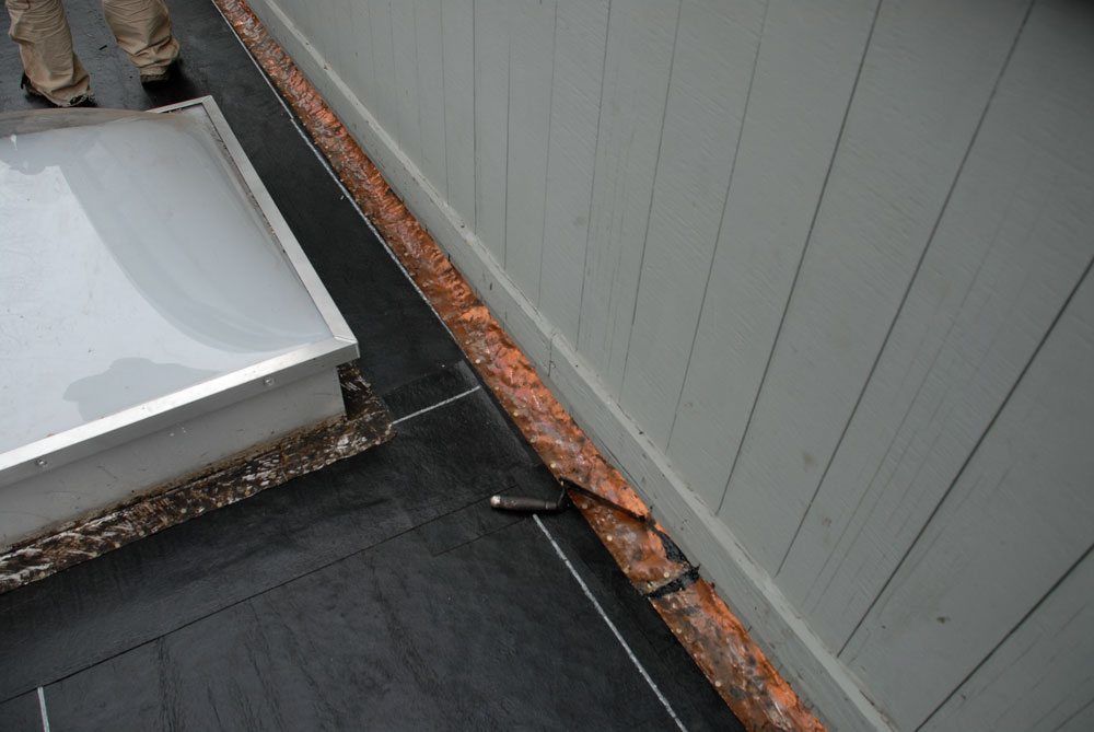Copper flashing on an old flat roof to be re-used Copper flashing on an old flat roof to be re-used