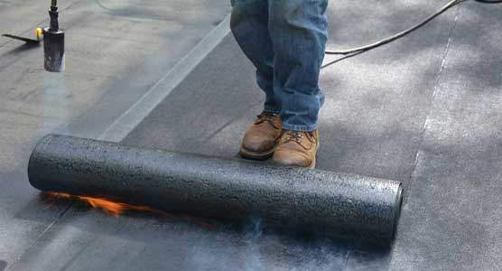 Modified Bitumen Torch Down Roofing membrane being Torched Down Torching down roofing or heat fusing a Modified Bitumen Rubber Membrane