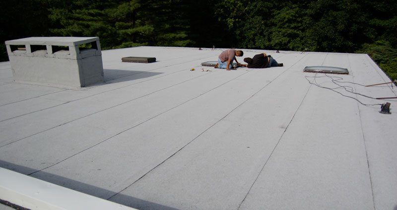 The image is an example of a 2 Ply Modified Bitumen Torch Down Rubber Roof System. Commercial Flat Roof - The image is an example of a 2 Ply Modified Bitumen Torch Down Rubber Roof System.